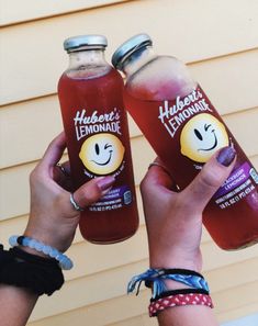 two people holding up bottles of lemonade in front of a house with the caption happy lemonade