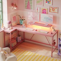 a pink desk and chair in a small room with pictures on the wall above it