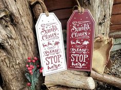 two wooden tags with santa claus and please stop me on them hanging from a tree