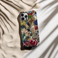 a phone case with an image of a cat on it sitting on top of sand