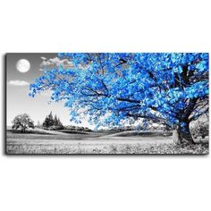 a large blue tree in the middle of a field with a full moon behind it