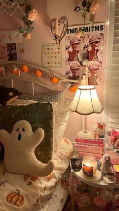 a bed with a ghost pillow on top of it next to a night stand and lamp