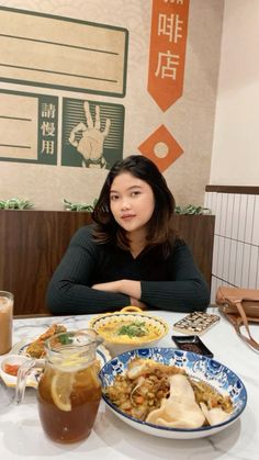 a woman sitting at a table with food in front of her