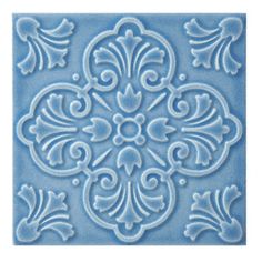 a blue tile with an ornate design on the front and back of it's surface