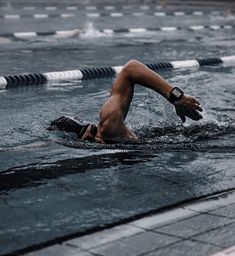 a man is swimming in the water with his hands on his hips and feet up