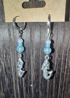 Silver mermaid charm and Blue gemstone bead dangle earrings. stainless steel.  huggie hoop clasp closure Bead Dangle Earrings, Silver Mermaid, Beaded Dangle Earrings, Blue Gemstones, Beaded Dangles, Gemstone Beads, Jewelry Earrings Dangle, Dangle Drop Earrings, Dangle Earrings