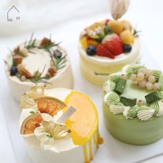 four small cakes decorated with fruits and flowers