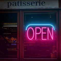 a neon sign that reads open in front of a store