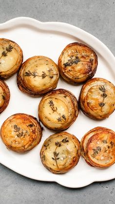 a white plate topped with cooked potatoes on top of a table