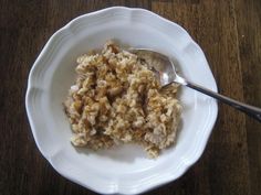 a white bowl filled with oatmeal on top of a wooden table