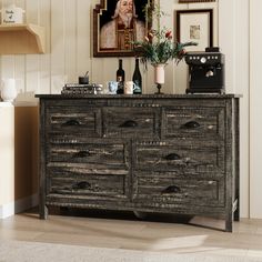 an old wooden dresser in a room with pictures on the wall