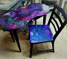 two chairs sitting next to each other in front of a table with an artistic design on it