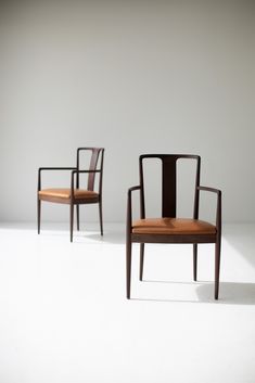 two chairs sitting next to each other on a white floor