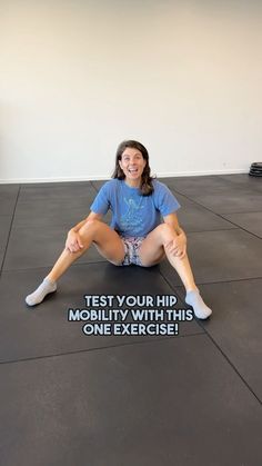 a woman is sitting on the floor with her legs crossed in front of her body