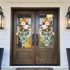 the front door is decorated with wreaths and lanterns