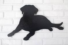 a black metal dog on a white brick wall