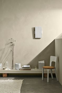 a room with a table, chair and lamp on it's side by the wall