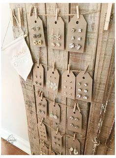 there are many tags hanging on the wall with clothes pins and earring clips attached to them