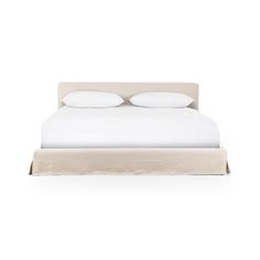 a white bed with two pillows on top of it