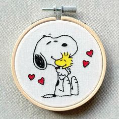 a cross stitch snoopy with hearts on it