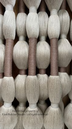 several skeins of yarn are arranged in rows on the wall, all white and brown