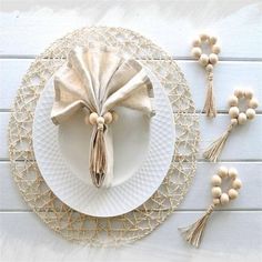 a white plate topped with a tasseled napkin next to other plates and decorations