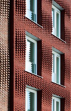 a red brick building with several windows on the front and side, all made out of small bricks