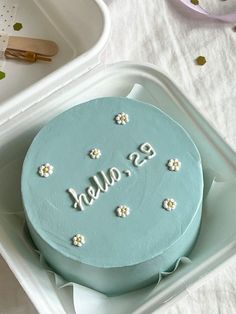 there is a blue cake with white flowers on it and the word b is also spelled in cursive letters