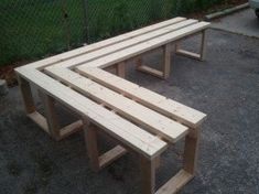 two wooden benches sitting next to each other on the ground near a fenced in area