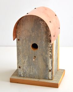 a wooden birdhouse sitting on top of a white table