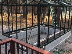 a greenhouse being built in the middle of a forest