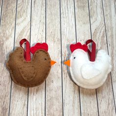 two stuffed chickens sitting next to each other on a wooden floor