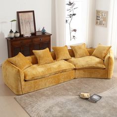 a yellow couch sitting on top of a rug in a living room