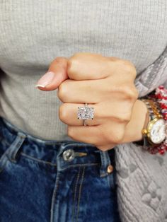 a woman's hand wearing a diamond ring