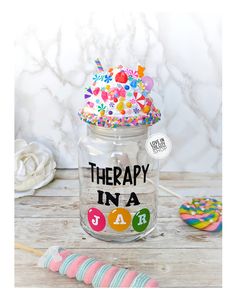 there is a jar with some candy in it and the lid says therapy in a jar