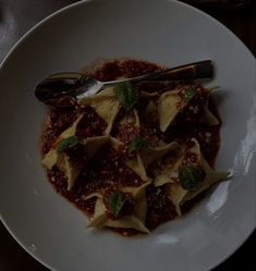 a white plate topped with ravioli and sauce