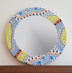 a colorful mirror sitting on top of a wooden shelf