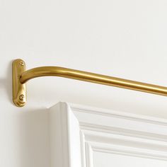 a close up of a gold handle on a white door