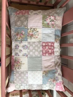 a pink bunk bed with a patchwork pillow