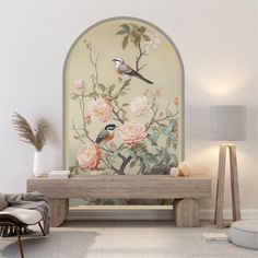 a living room with flowers and birds painted on the wall next to a bench in front of a window