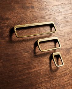 two metal handles sitting on top of a wooden table