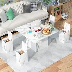 a living room with white furniture and wooden floors