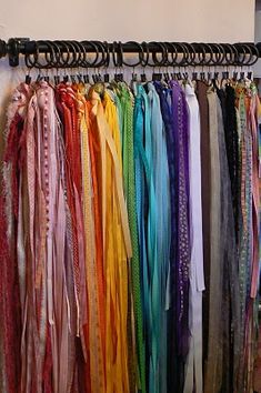 there is a rack with many different colored ties on the clothes hanger in front of it