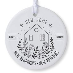 a white ceramic ornament with the words new home and a house surrounded by plants