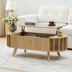 a living room with a white couch and coffee table in the middle, on top of a rug