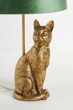 a golden cat sitting under a green lamp