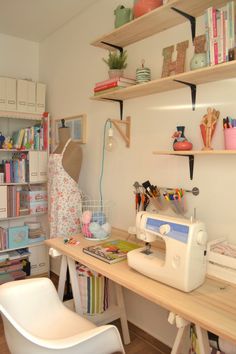 a sewing machine sitting on top of a wooden table next to a white plastic chair