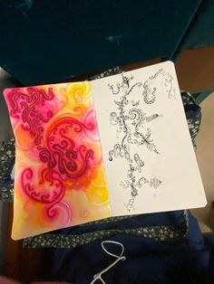 two notebooks with designs on them sitting next to each other