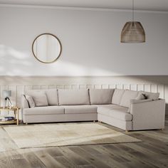 a living room with white walls and wood flooring on the wooden floor, along with a beige sectional sofa