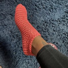 a person's feet with red socks on top of blue carpeted flooring